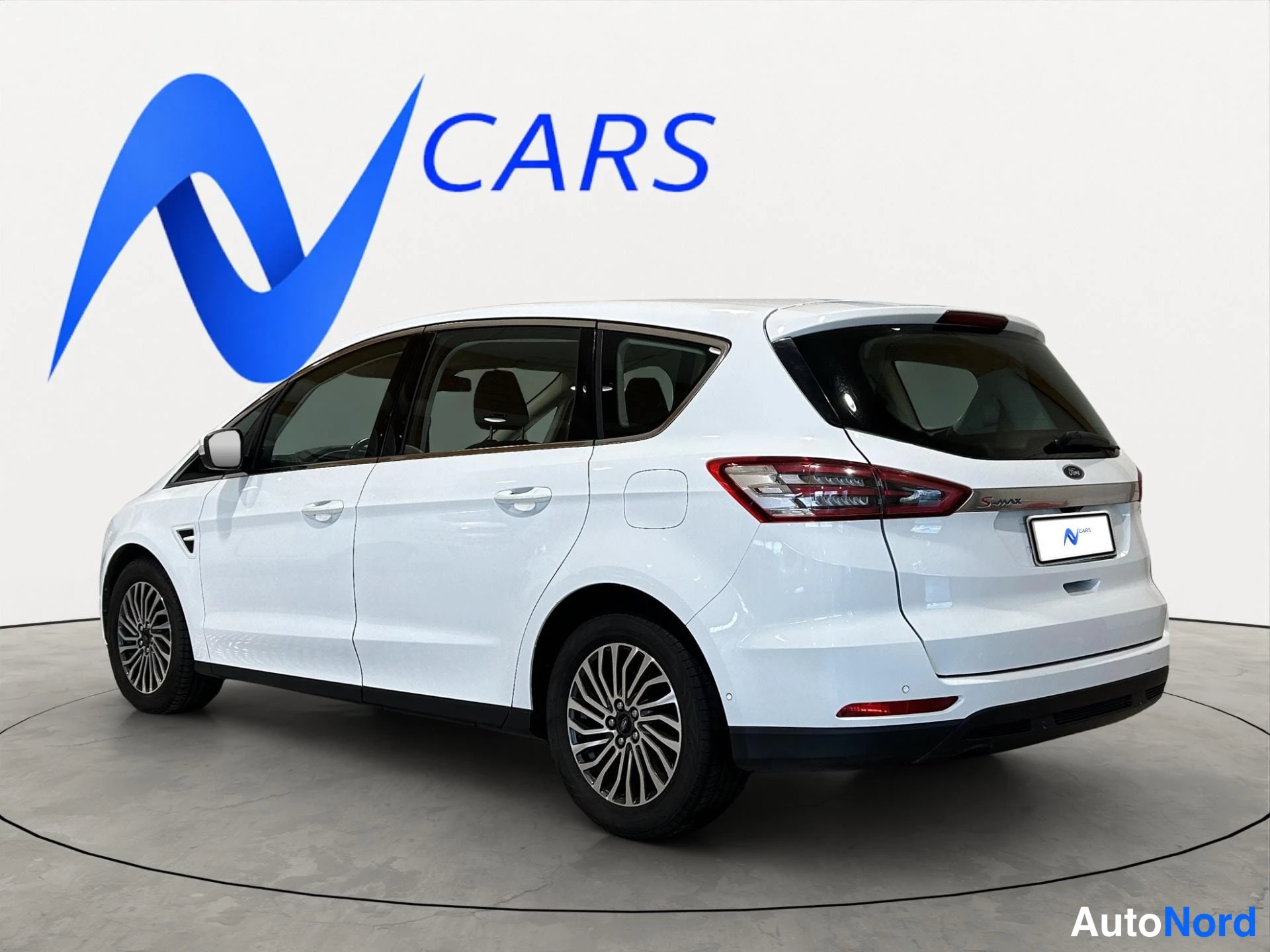 Takaviisto: Valkoinen Ford S-MAX -tilasmaasturi kulmassa takaa oikealta, takaosa ja sivu näkyvissä.