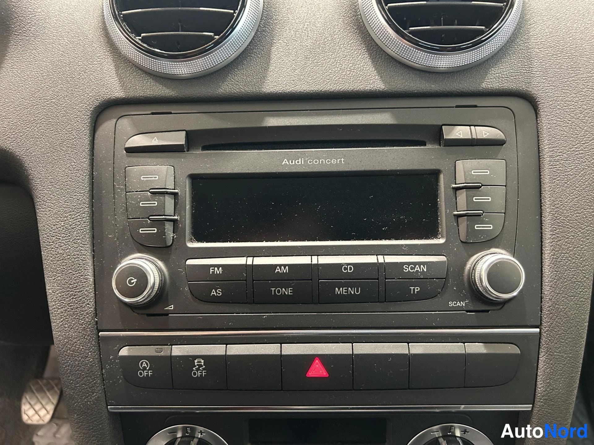 Muu: Kojelaudan radiopaneeli lähikuvassa: 'Audi concert' -yksikkö ja OFF-merkitsevät kytkimet.