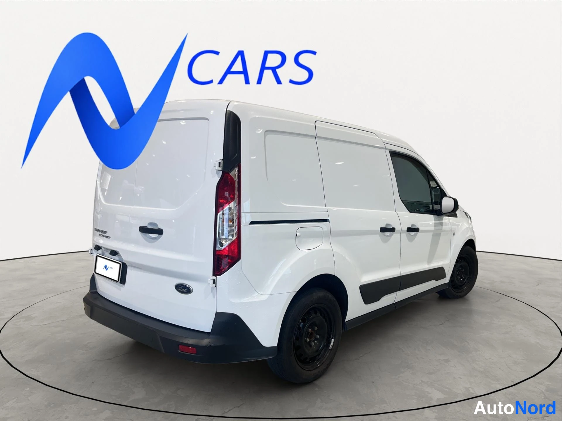 Takaviisto: Valkoinen Ford Transit Connect -pakettiauto takakulmasta vasemmalta, peräosat ja vasen kylki näkyvissä.