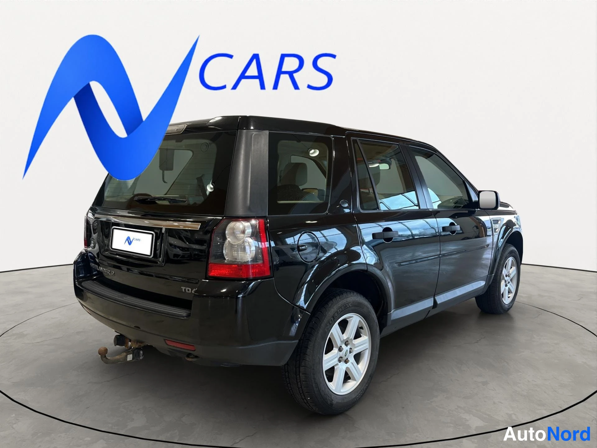 Takaviisto: Land Rover Freelander 2 takaa sivulta, musta koripaintti, takaluukku ja vasemman puoleiset ovet näkyvät, hopeavanteet.
