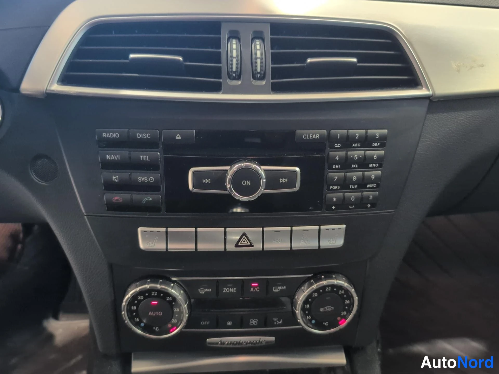 Muu: Keskikonsolin paneli: radio- ja navigointipainikkeet (RADIO, DISC, NAVI, TEL, SYS, CLEAR), numeronäppäimet, kaksivyöhykeilmastointi (ZONE, A/C, AUTO) ja hazard-