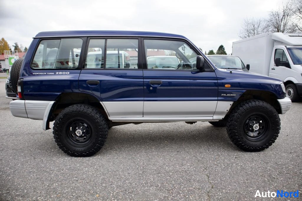 Sivulta: Tummansinisen Mitsubishi Pajeron sivunäkymä vasemmalta, kyljessä teksti Intercooler Turbo 2800 ja Pajero.