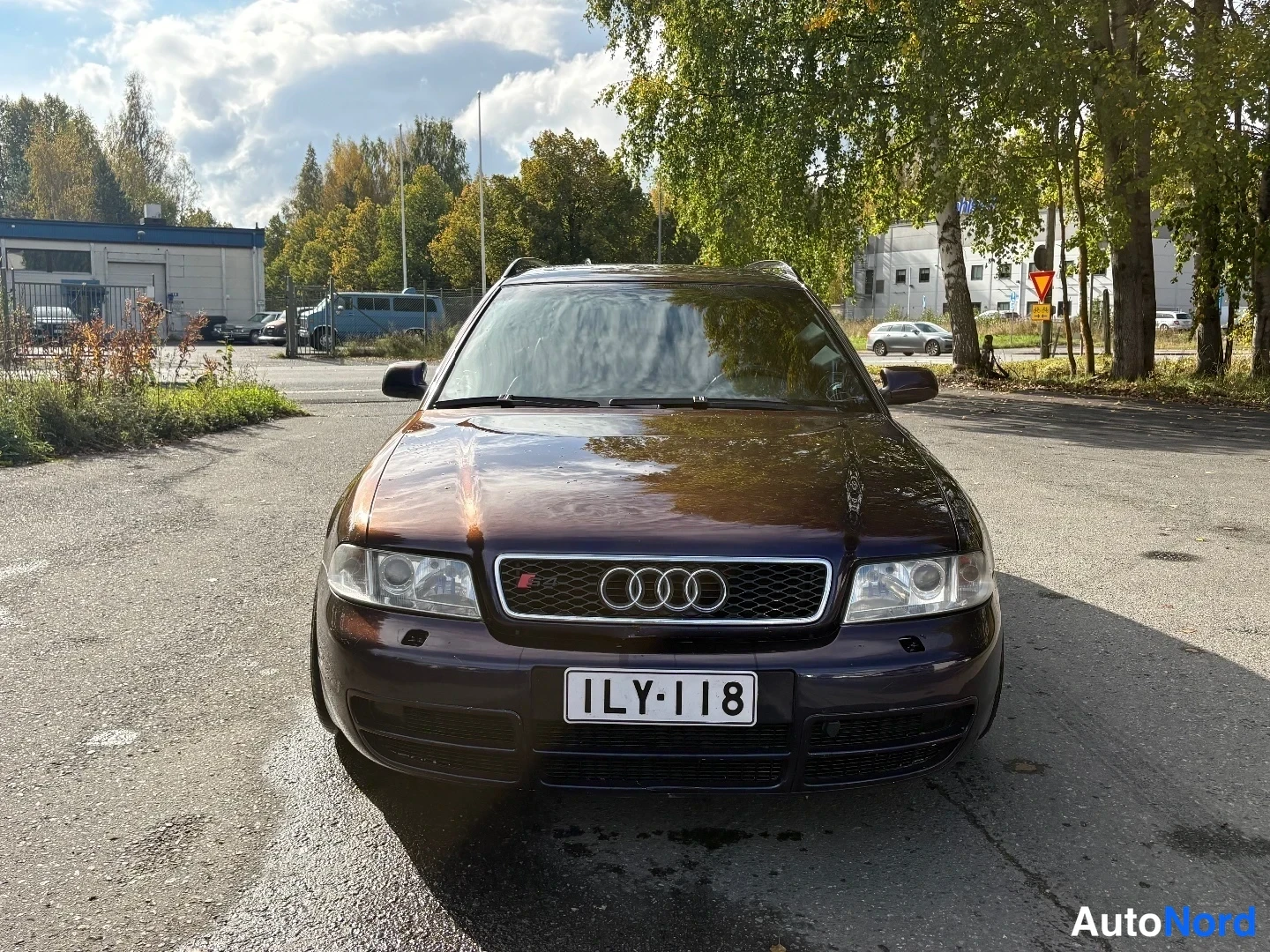 Edestä: Tummansinisen violetti Audi A4 -farmari suoraan edestäpäin, etusäleikkö ja Audi-logot, rekisteritunnus.