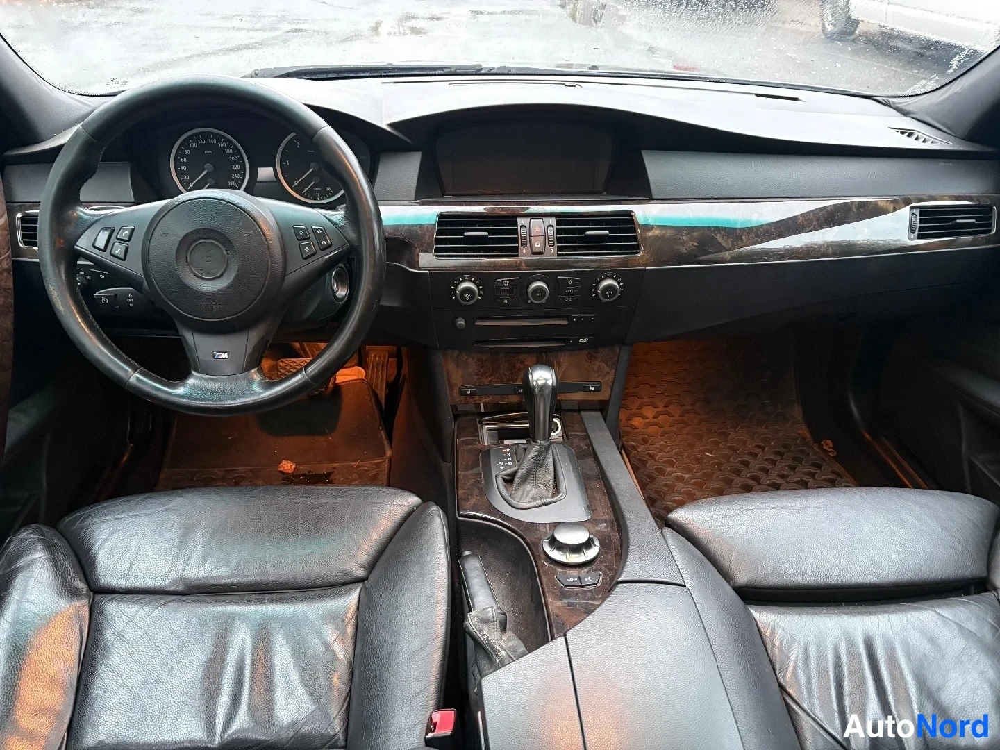 Muu: Ohjaamo eteenpäin kuvattuna: ohjauspyörä, mittaristo, automaattivaihtajan valitsin ja iDrive-ohjain.