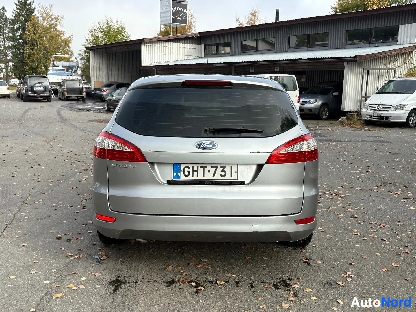 Takaa: Ford Mondeo Farmari suoraan takaa kuvattuna, hopeametallinen korimalli autotallin edustalla.