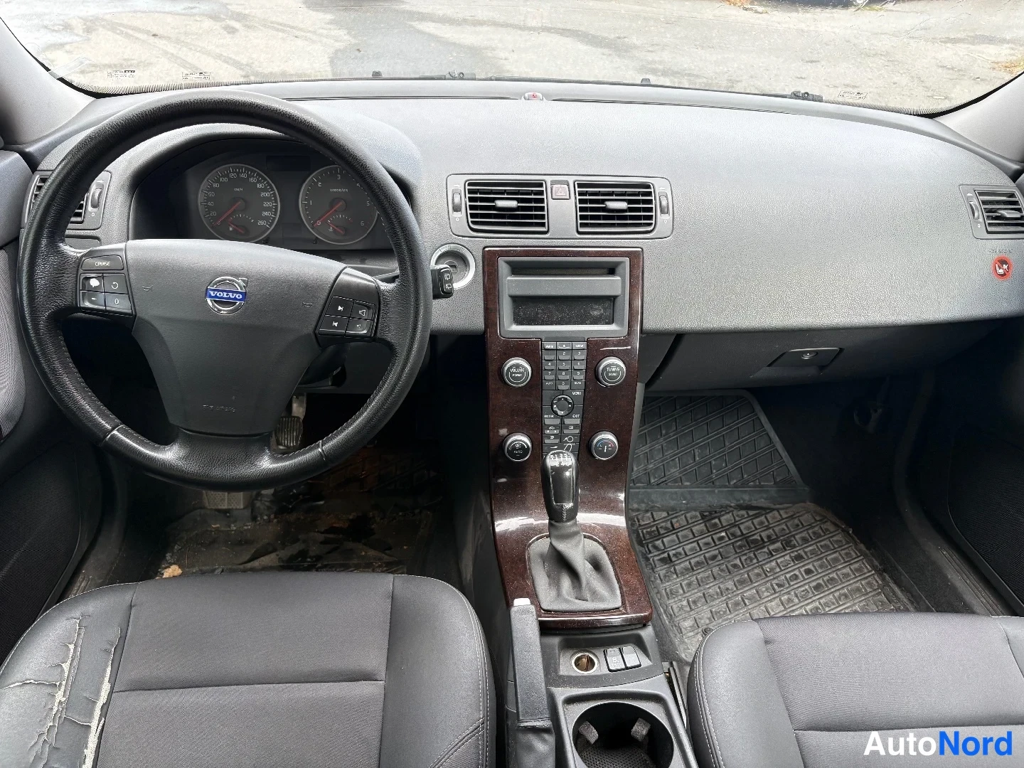 Muu: Sisäkuva kojelautaan päin: Volvo-ohjauspyörä, mittaristo, keskitunnin äänentoistolaite ja automaattivaihteen valitsin.