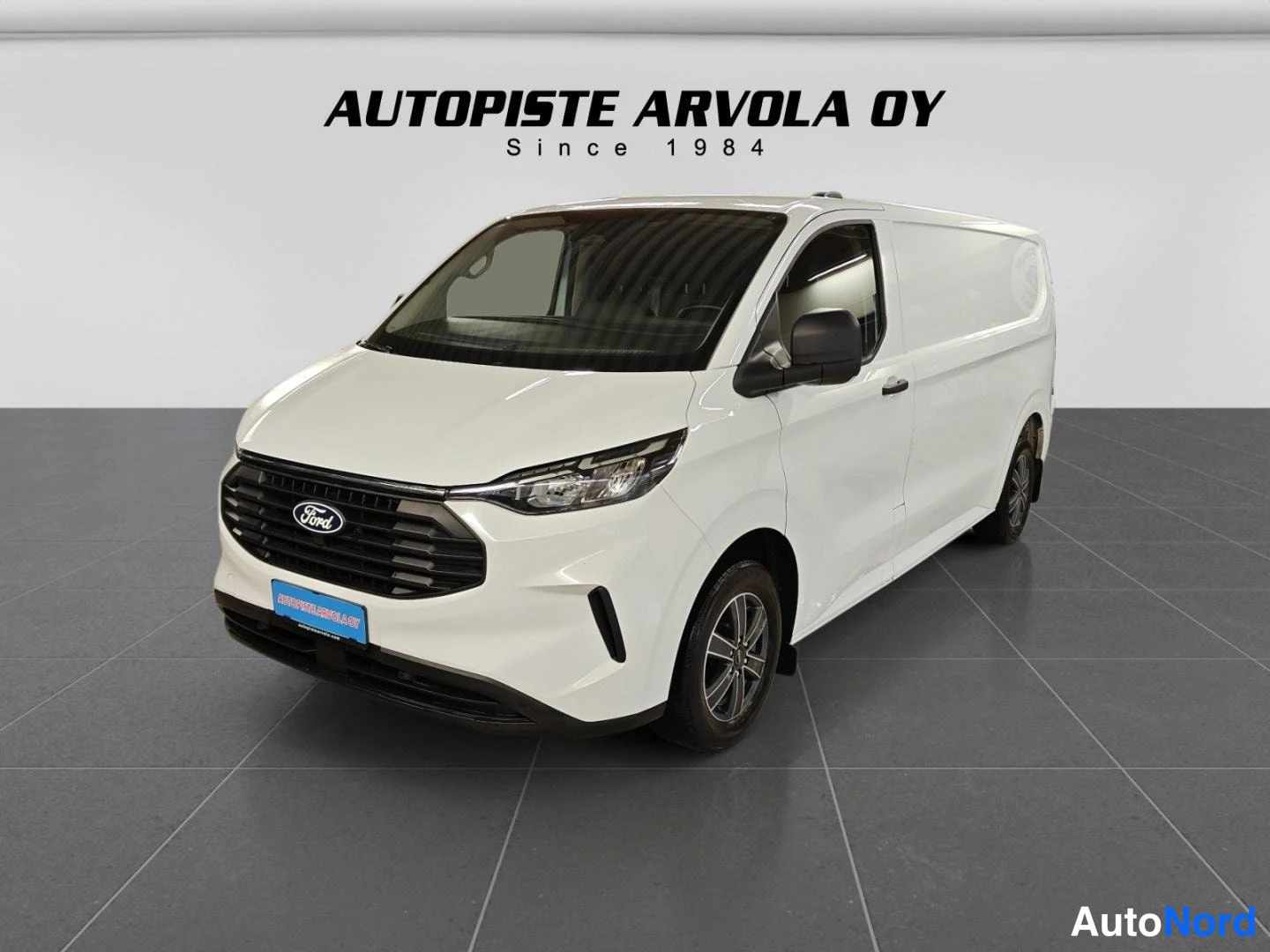 Etuviisto, nokka vasemmalle: Ford Transit Custom -pakettiauto etuviistosta vasemmalle, valkoinen korisävy.