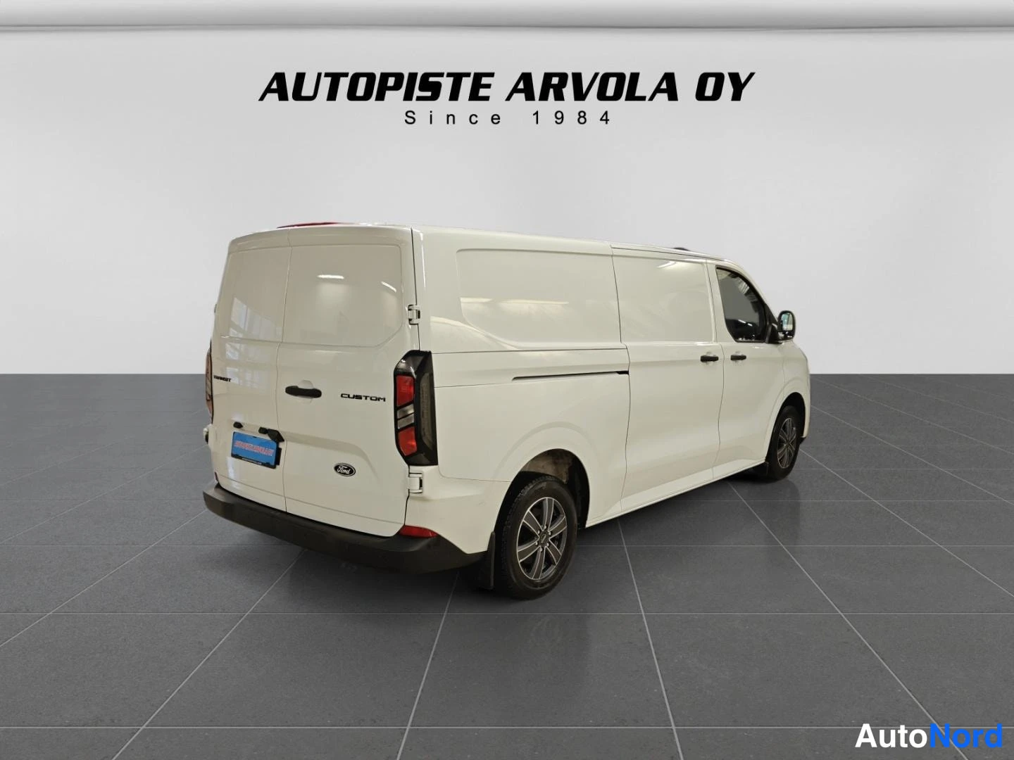 Takaviisto: Ford Transit Custom -pakettiauto takaviistosta oikealle, valkoinen korisävy.