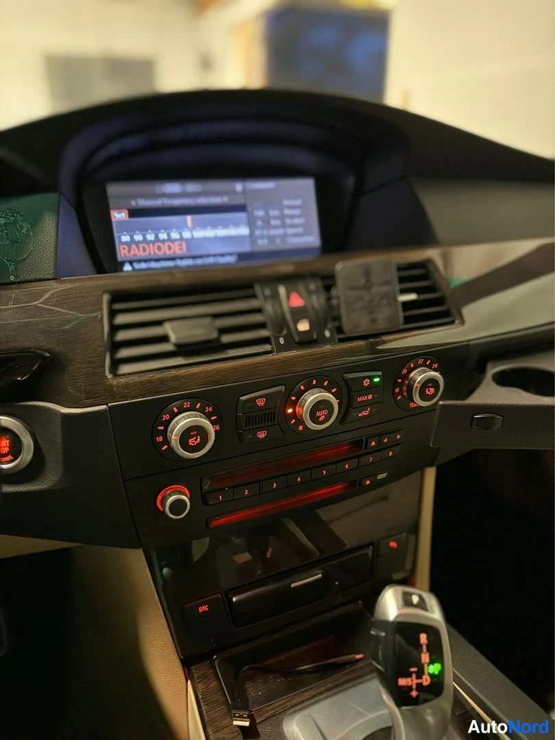 Muu: Auton kojelauta: näyttö jossa RADIODE1, ilmastointisäätimet ja automaattivaihteen valitsin P-R-N-D-asennossa.