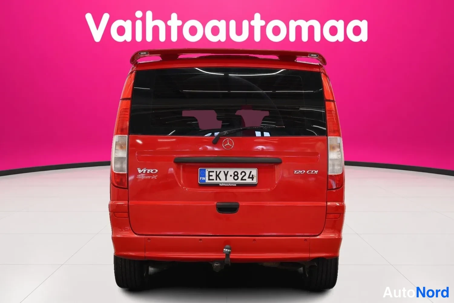 Takaa: Mercedes-Benz Vito:tta takaa: punainen koripaneeli, takavalot, rekisteritunnus ja hinauskoukku.