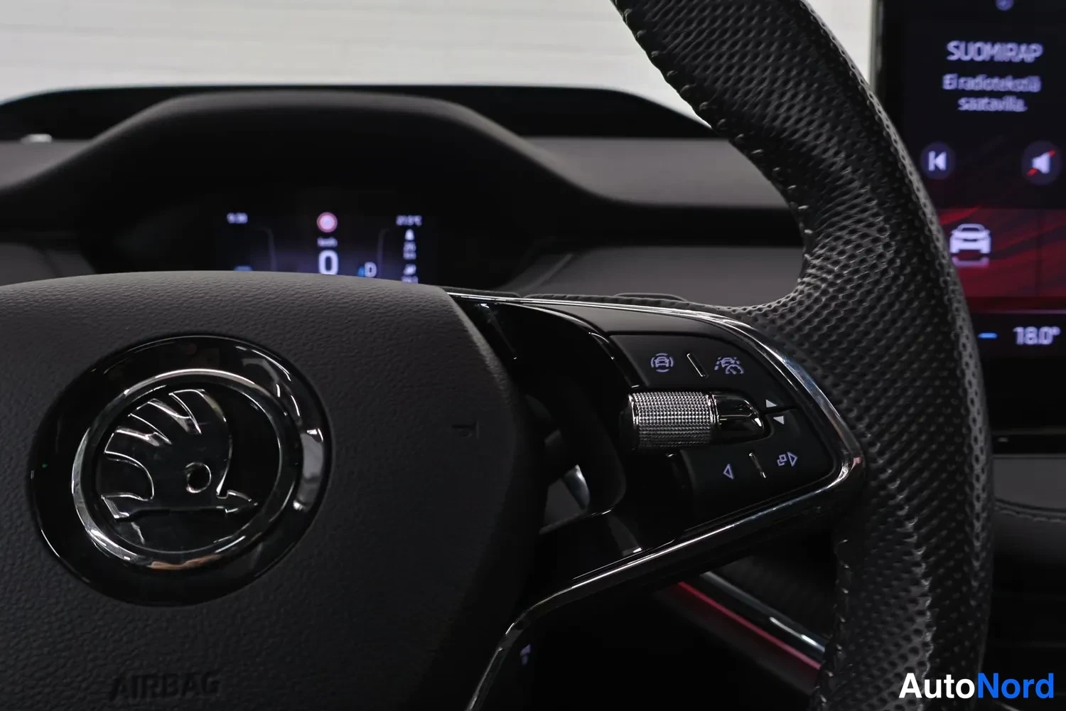 Muu: Ohjauspyörän oikea palkki Skoda-logolla ja monitoiminapeilla; takaan näkyy infonäyttö ja mittaristön digitaalinäyttö.