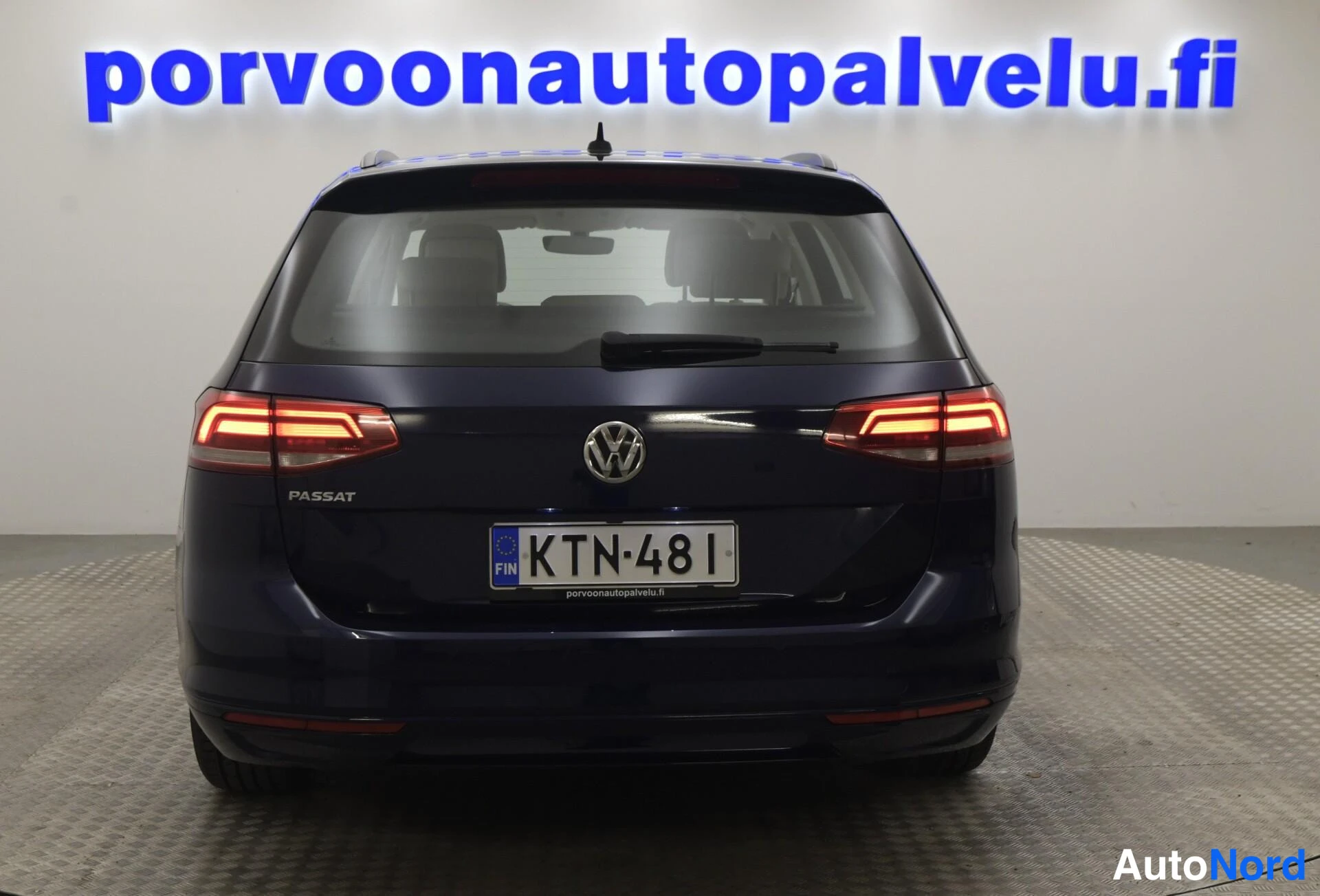 Takaa: Sininen farmariauto takaa kuvattuna, tuuliluvun pylpyrät, PASSAT-merkintä ja rekisterikilpi näkyvät.