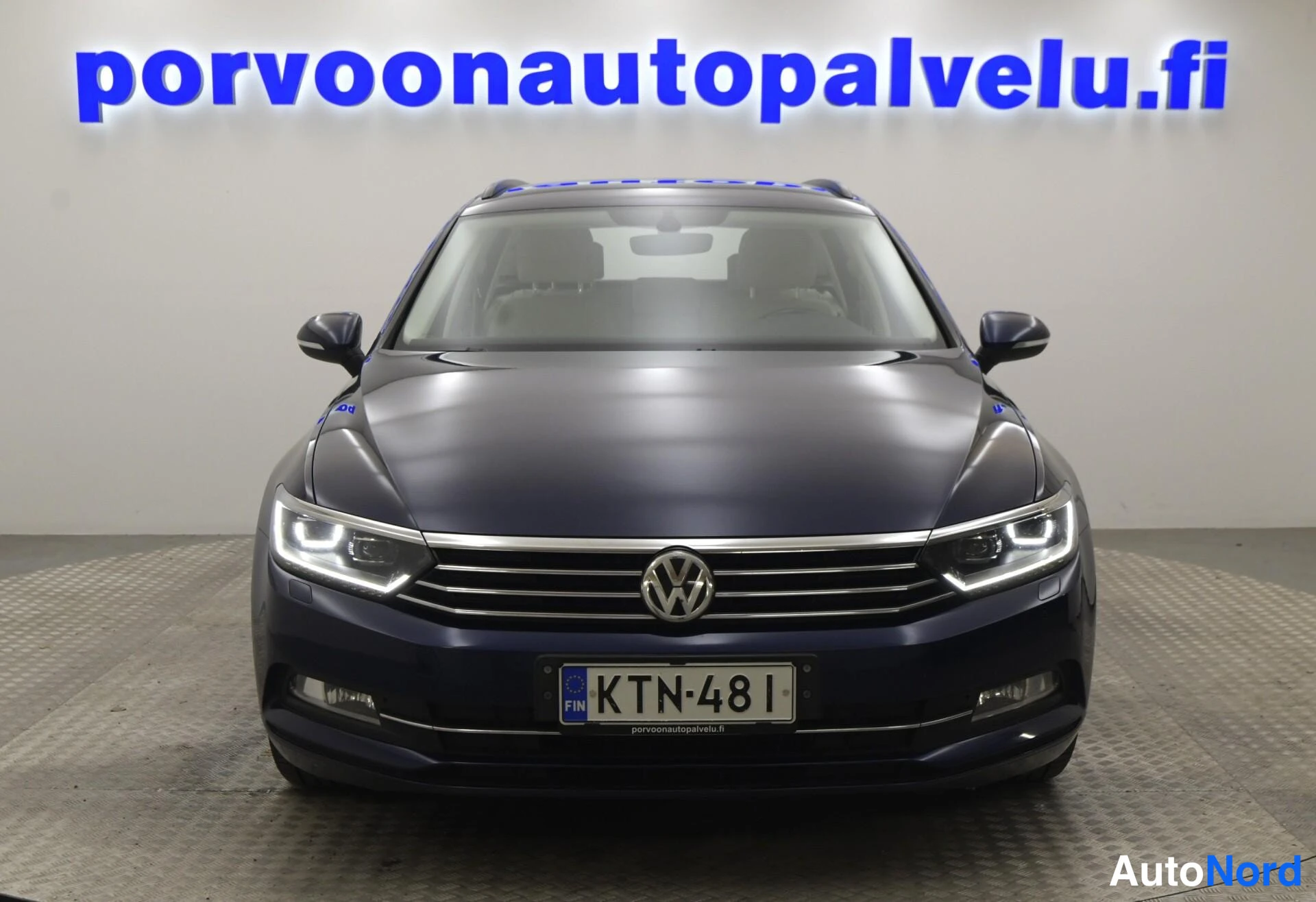 Edestä: Volkswagen Passat Variant -farmari suoraan edestä kuvattuna, tummansininen