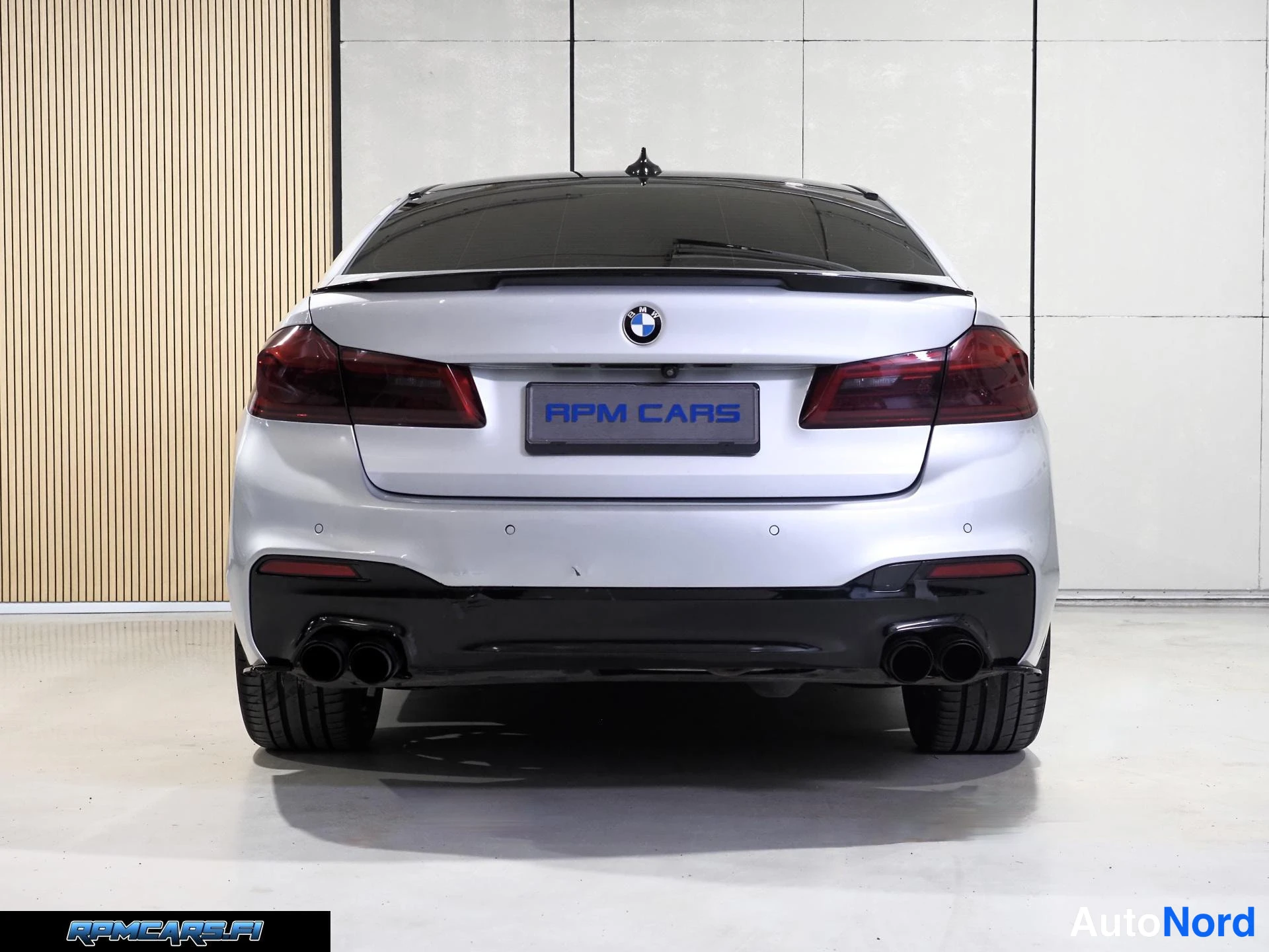 Takaa: Hopeinen BMW-sedan takaapäin, musta spoileri ja neljä pakoputkea