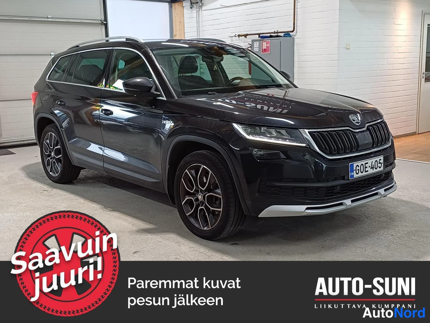 Etuviisto, nokka oikealle: Tummanruskea Skoda Kodiaq -maasturin etukulmakuva sisätiloissa, etusäiliö ja kylki näkyvät, rekisteri.