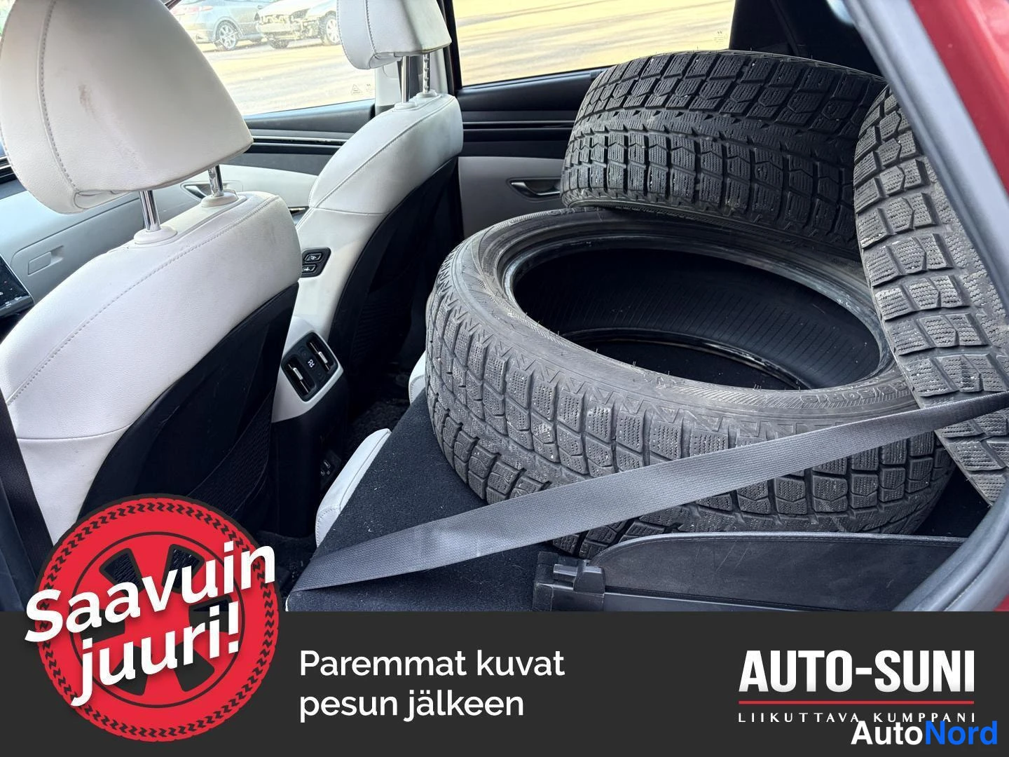 Muu: Hyundai Tucsonin tavaratilaan lastattu neljä renkaita, matkalaukkuteline ja tavaraverho näkyvät, valkoharmaat istuimet takaa katsottuna.