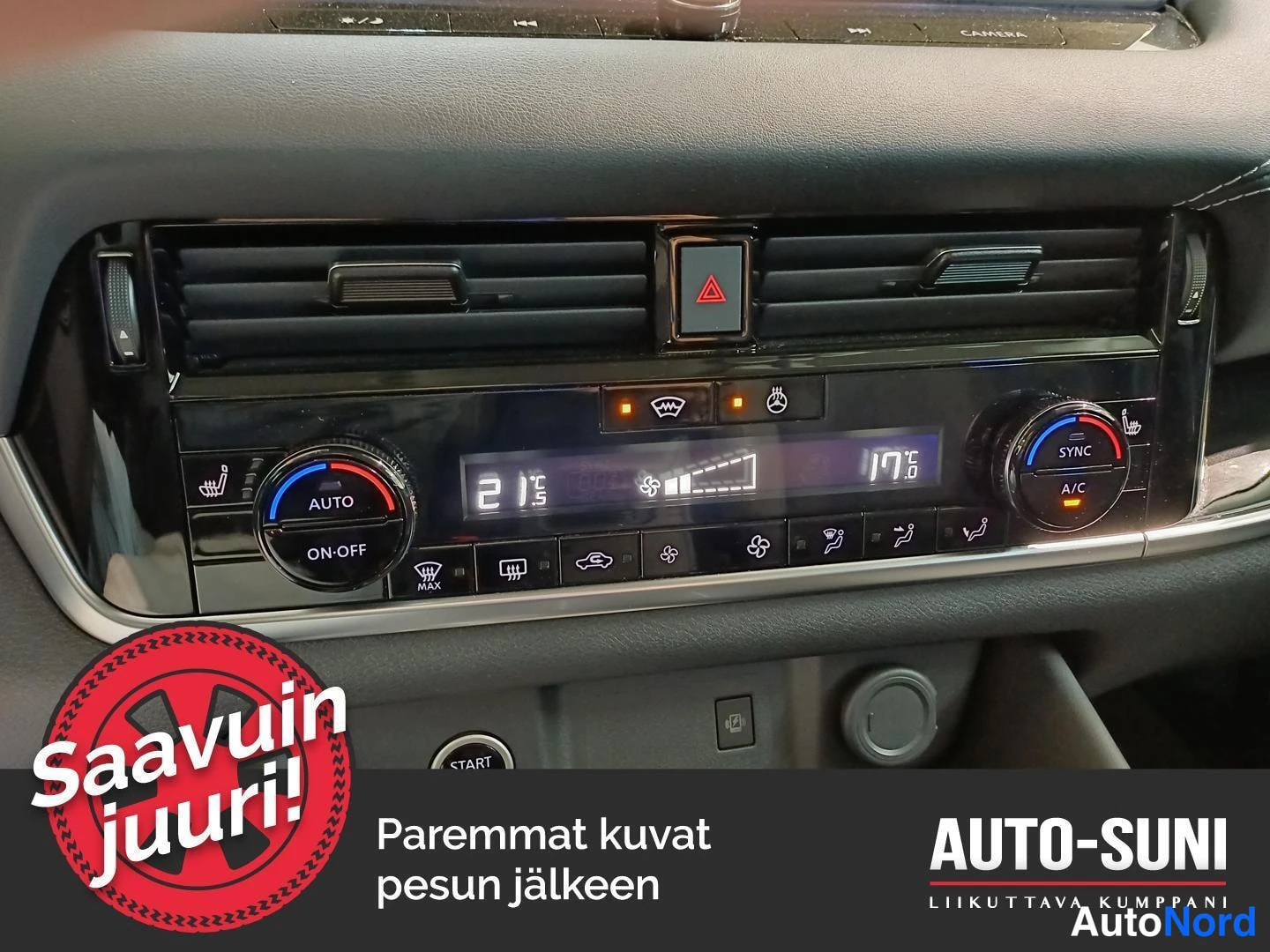 Yksityiskohta: Lähikuva kojelaudan ilmastointipaneelista: AUTO/ON-OFF-nappi, lämpötilat 21,5 ja 17,5 astetta, SYNK- ja A/C-napit sekä painonapit.
