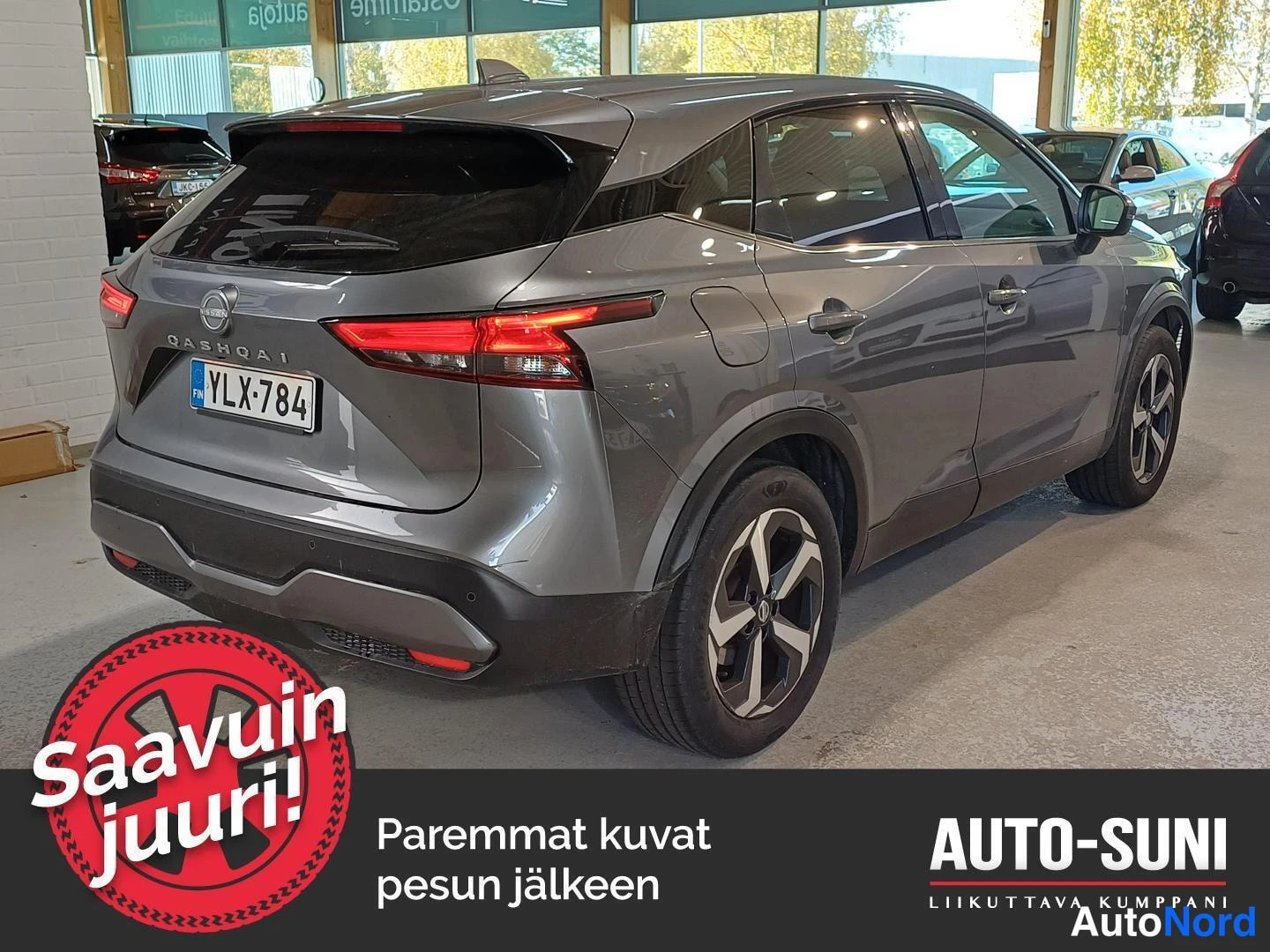 Takaviisto: Hopeanharmaa Nissan Qashqai takaviistosta oikealta, takavalot, -kilpi ja pystysuora punkki näkyvät autosalissa.