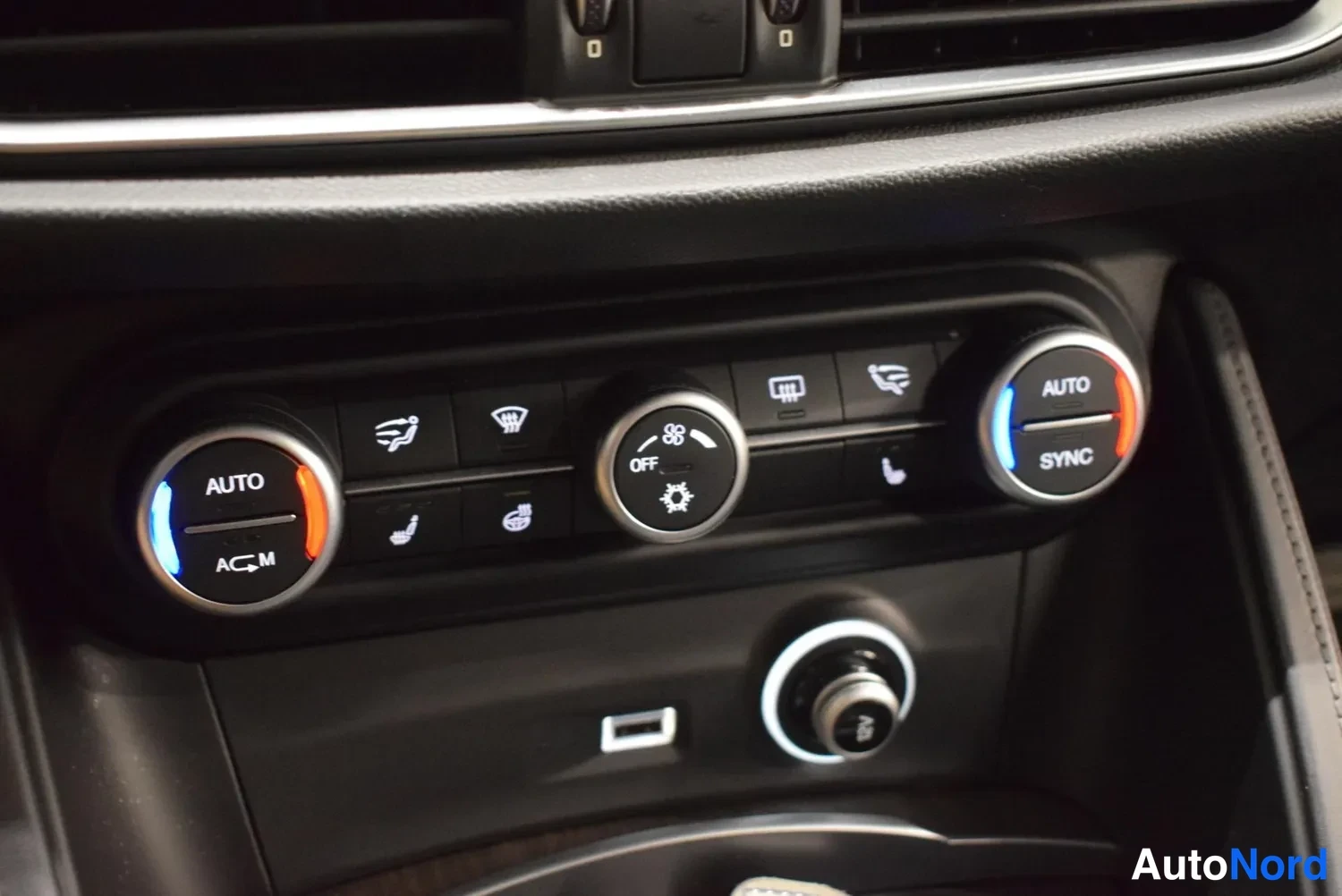 Muu: Kojelaudan ilmastointipaneeli AUTO- ja SYNC-kehyksillä, lämpötilanüükkeillä ja OFF-kohdalla.