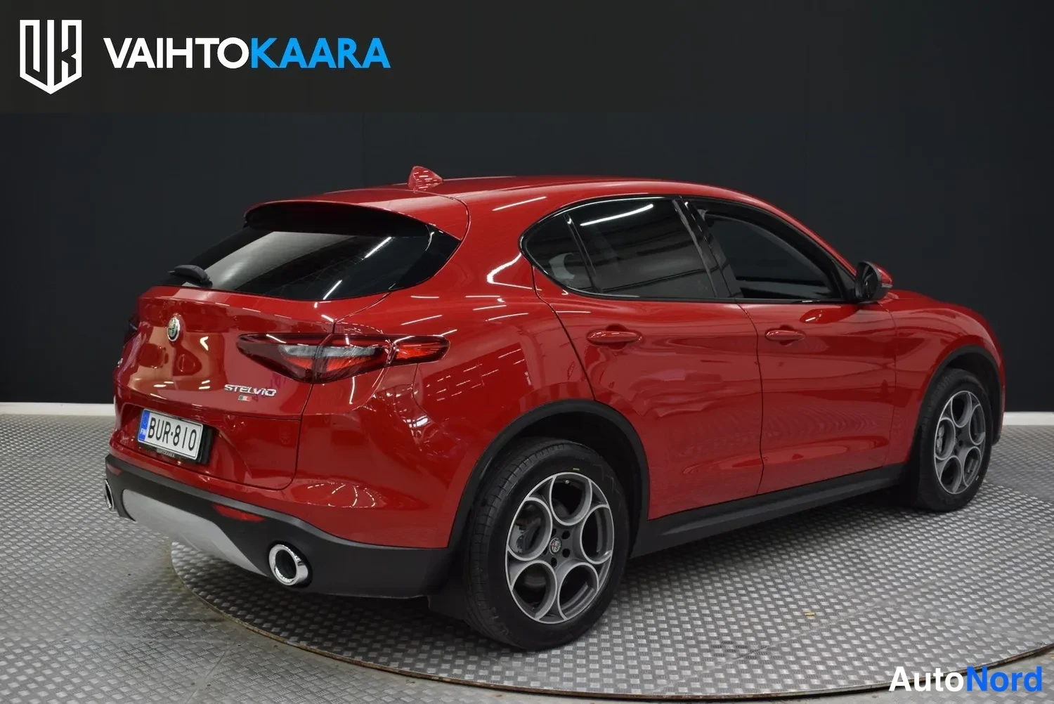 Takaviisto: Punainen Alfa Romeo Stelvio takaa oikealle näkyvissä, taka ja oikea sivu