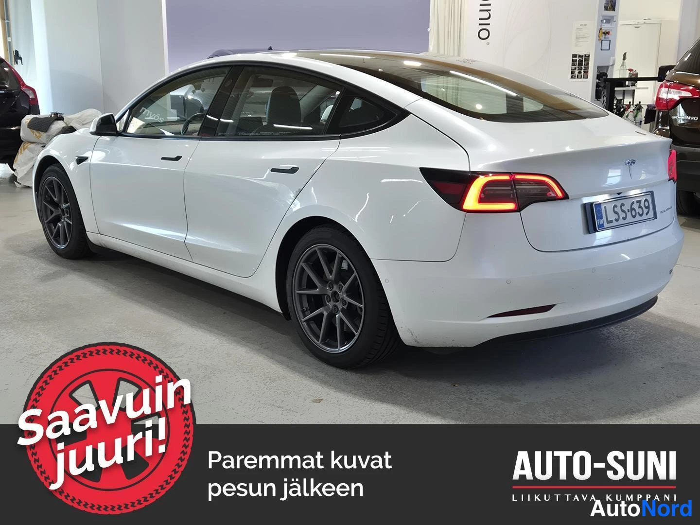 Takaviisto: Valkoinen henkilöauto takaa sivusuunnassa kuvattuna huoltotilassa.