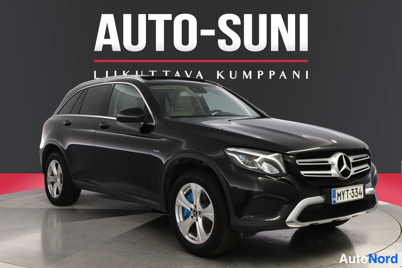 Etuviisto, nokka oikealle: Musta Mercedes-Benz GLC nyt etu- ja kylkipuoli näkyvissä, rekisteritunnus, AutoSuni-tausta.