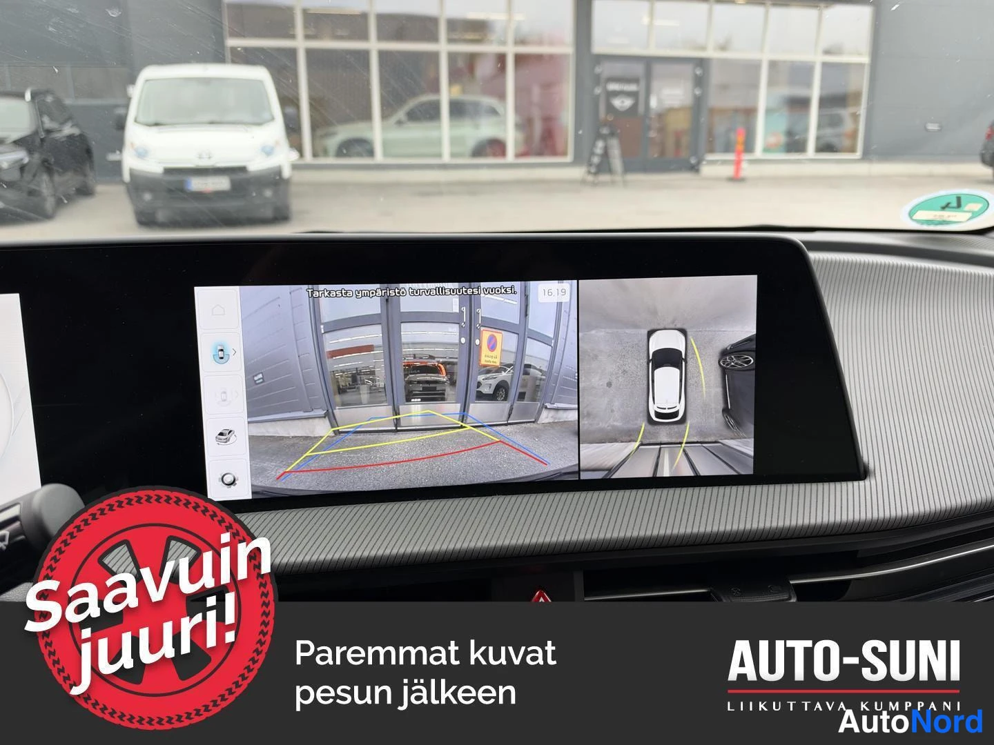 Muu: Kojelaudan näyttö, jossa näkyy peruutuskameran kuva ja ympärivuoristotarkistusviesti.