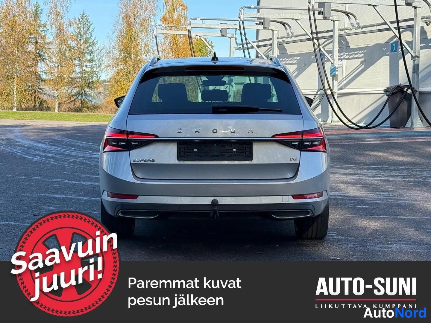 Takaa: Hopeanharmaan farmariauton takaosa suoraan takaa kuvattuna; näkyvissä Skoda-teksti, SUPERB- ja iV-merkit, takavalot ja vetokoulu.