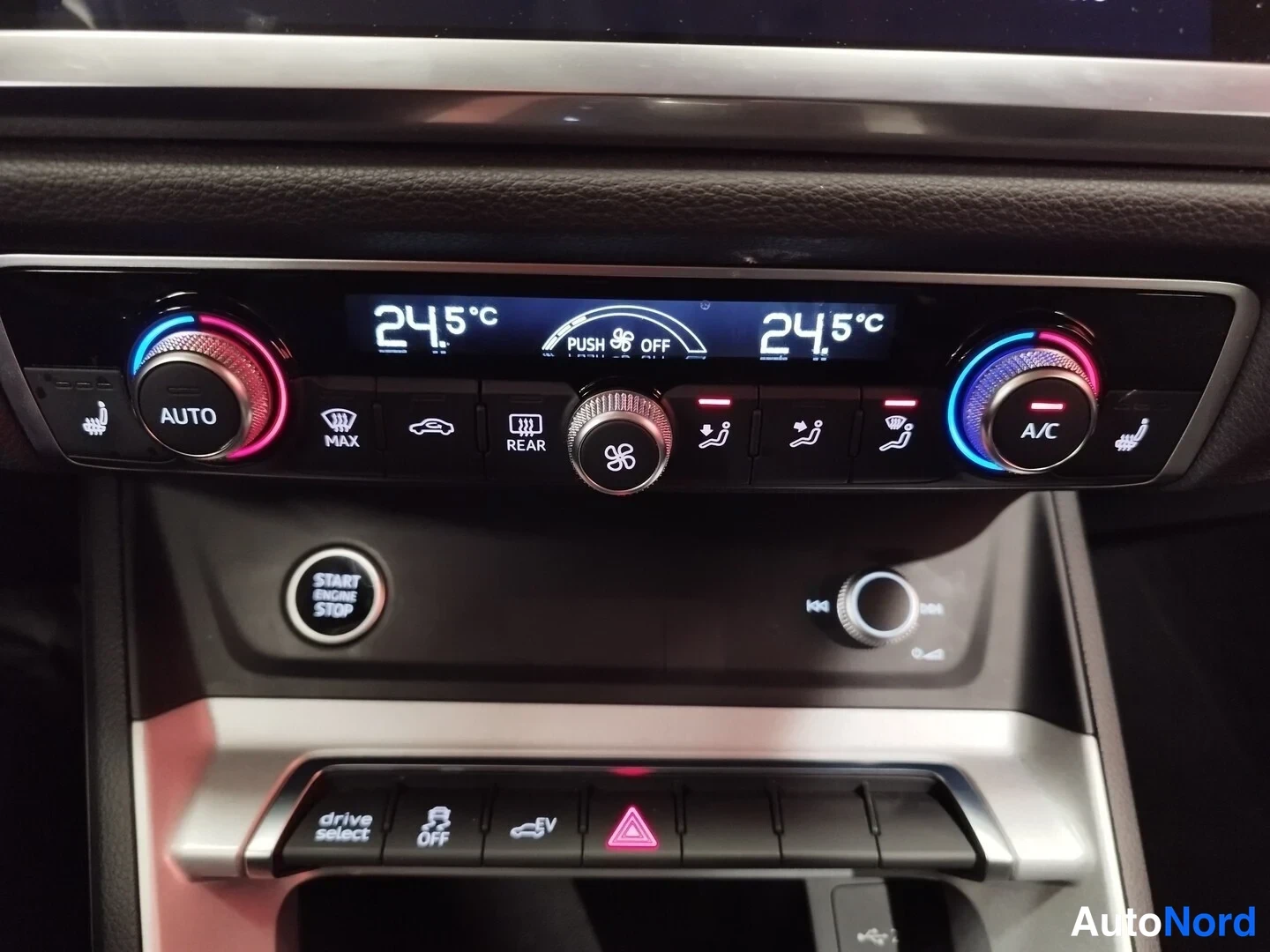 Edestä: Keskikonsolin ilmastointipaneeli näyttää 24,5 °C molemmin puolin, AUTOn ja A/C-napit, START ENGINE STOP -painike ja drive select -valinta.