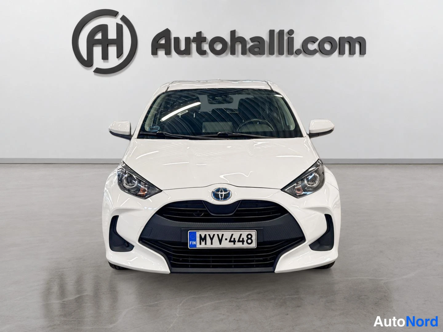 Edestä: Valkoinen Toyota Yaris suoraan edestä, rekisteritunnus