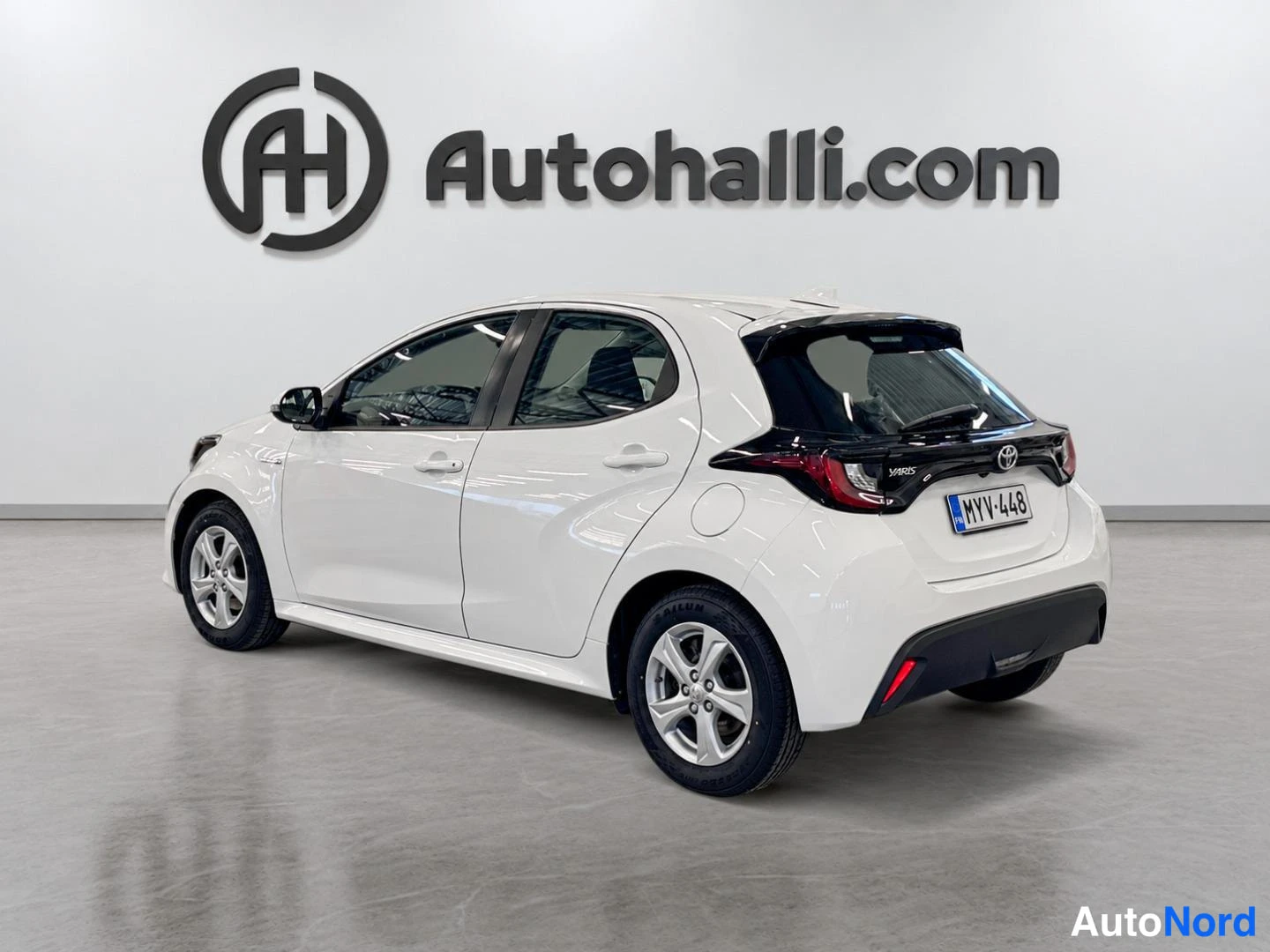 Takaviisto: Valkoinen Toyota Yaris takakulmasta oikealta, rekisteritunnus.