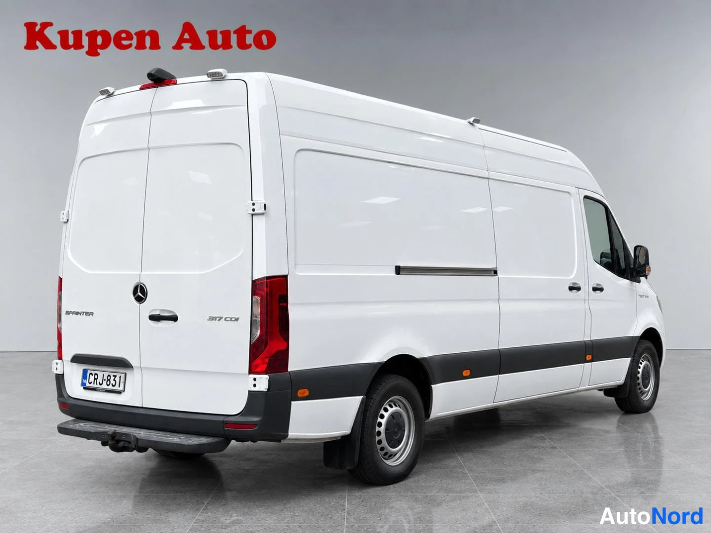 Takaviisto: Valkoinen Mercedes-Benz Sprinter -pakettiauto takaviistosta vasemmalta, takaluukkien Sprinter- ja 317 CDI -tekstit, rekisteritunnus.