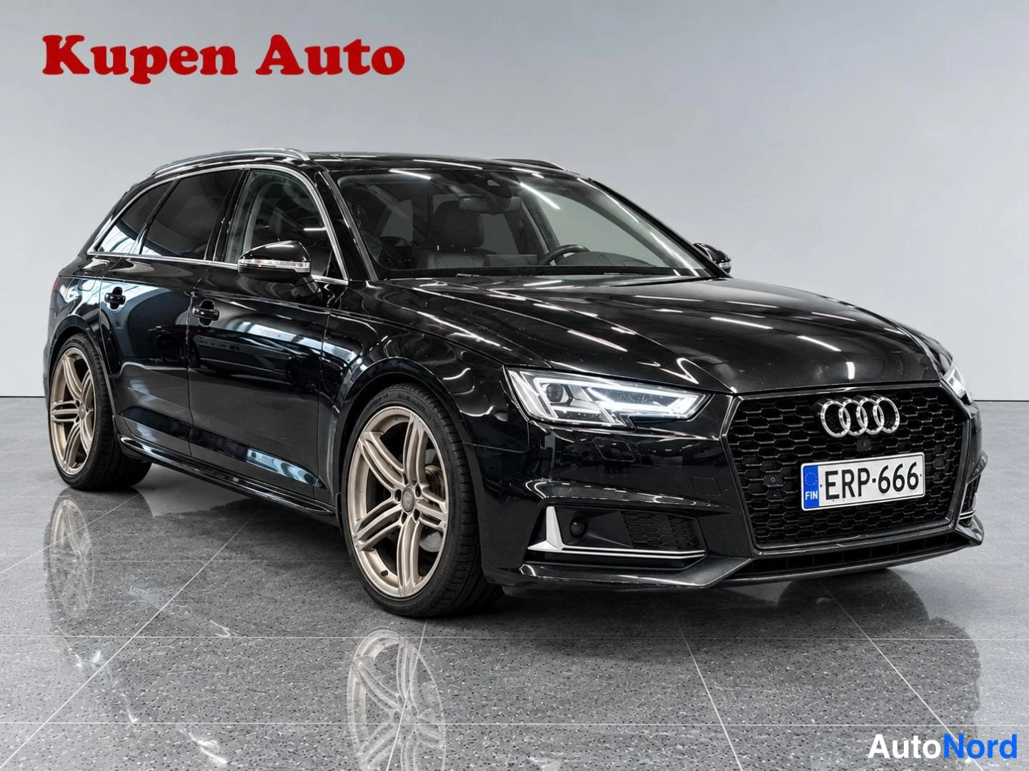 Etuviisto, nokka oikealle: Mustan Audi A4 Avant -farmarin etukulmakuva oikealta, rekisteritunnus, harmaassa studiossa.