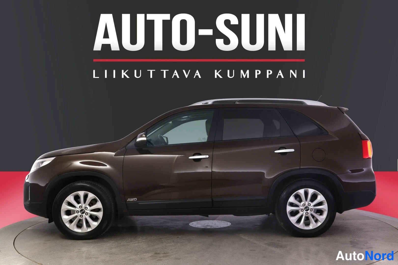 Etuviisto, nokka vasemmalle: Kia Sorento 2013 sivusta etukulmasta, tummanruskea, AWD-tarra ovessa.