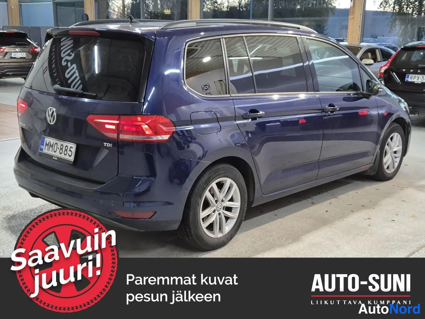 Takaviisto: Tummansininen Volkswagen Touran takaa vasemmalta vinosta, rekisterikilpi.