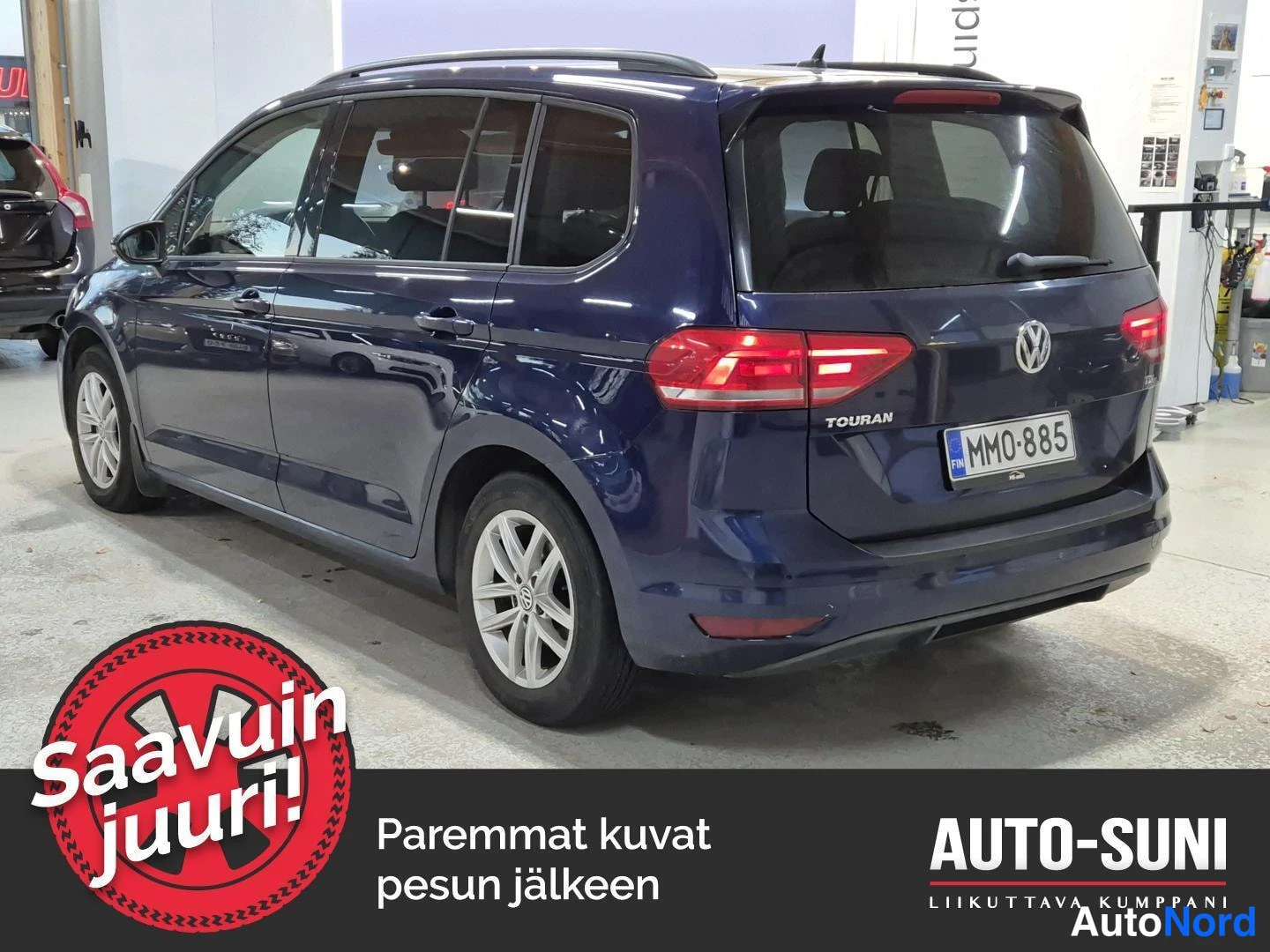 Takaviisto: Tummansininen Volkswagen Touran takaa oikealta vinosta, rekisterikilpi, TOURAN-merkintä takaluukussa.