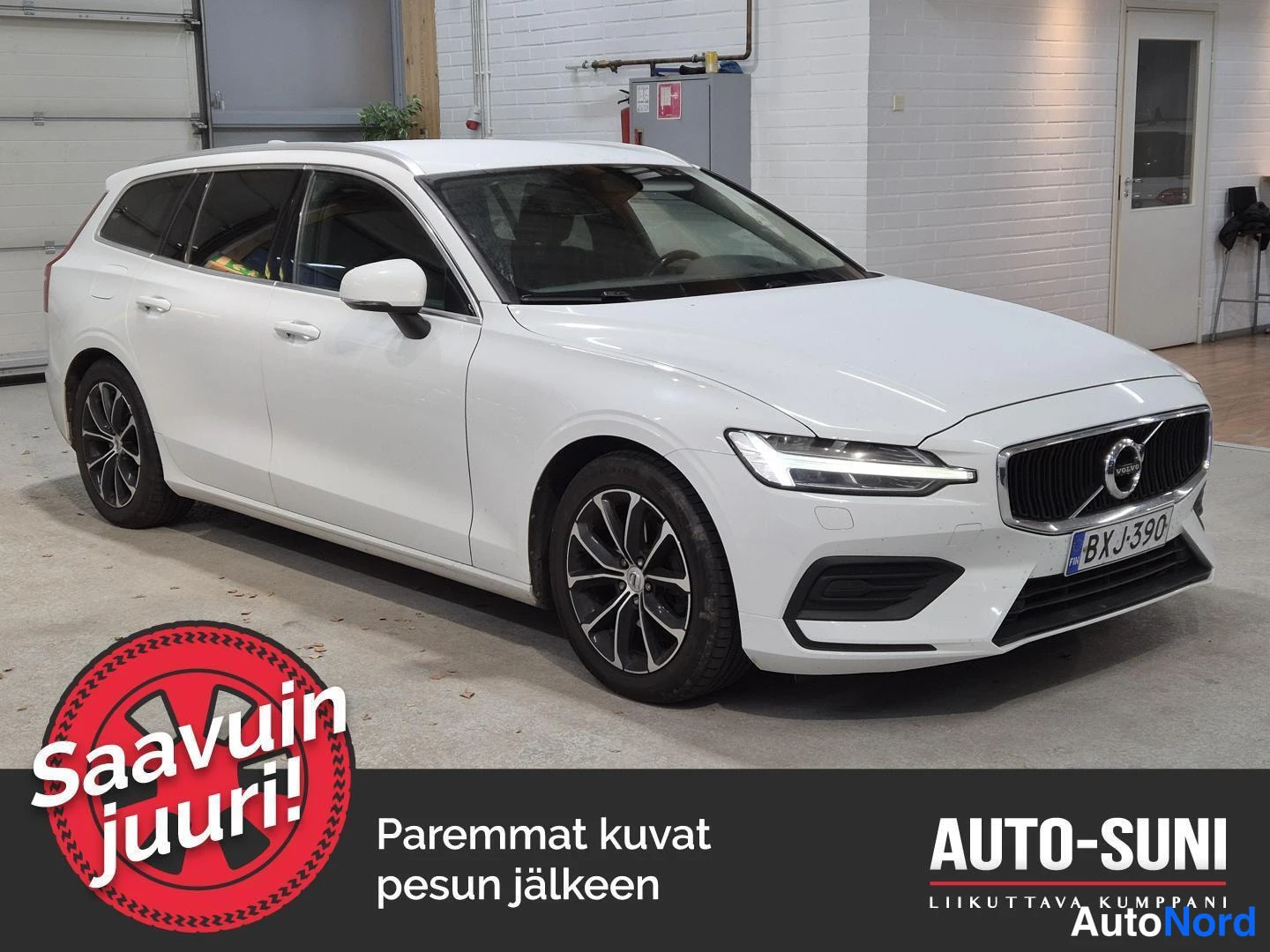 Etuviisto, nokka oikealle: Valkoinen farmariauto kulmassa kuvattuna edestä oikealta, etusäleikkö ja takapyörät näkyvät sisätiloissa.