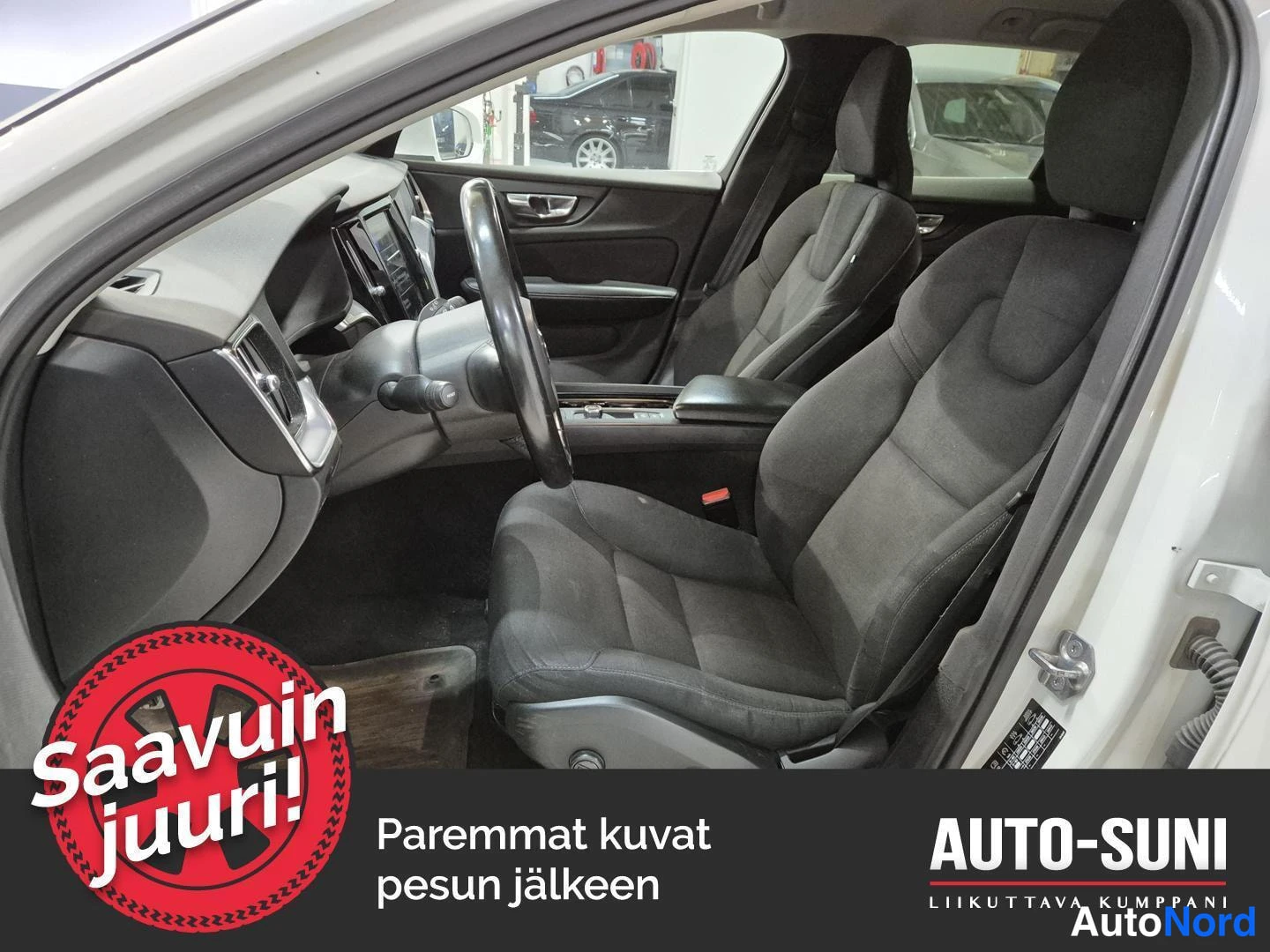 Muu: Auton etupenkit ja kojelauta kuvattuna avoimesta kuljettajan ovesta.