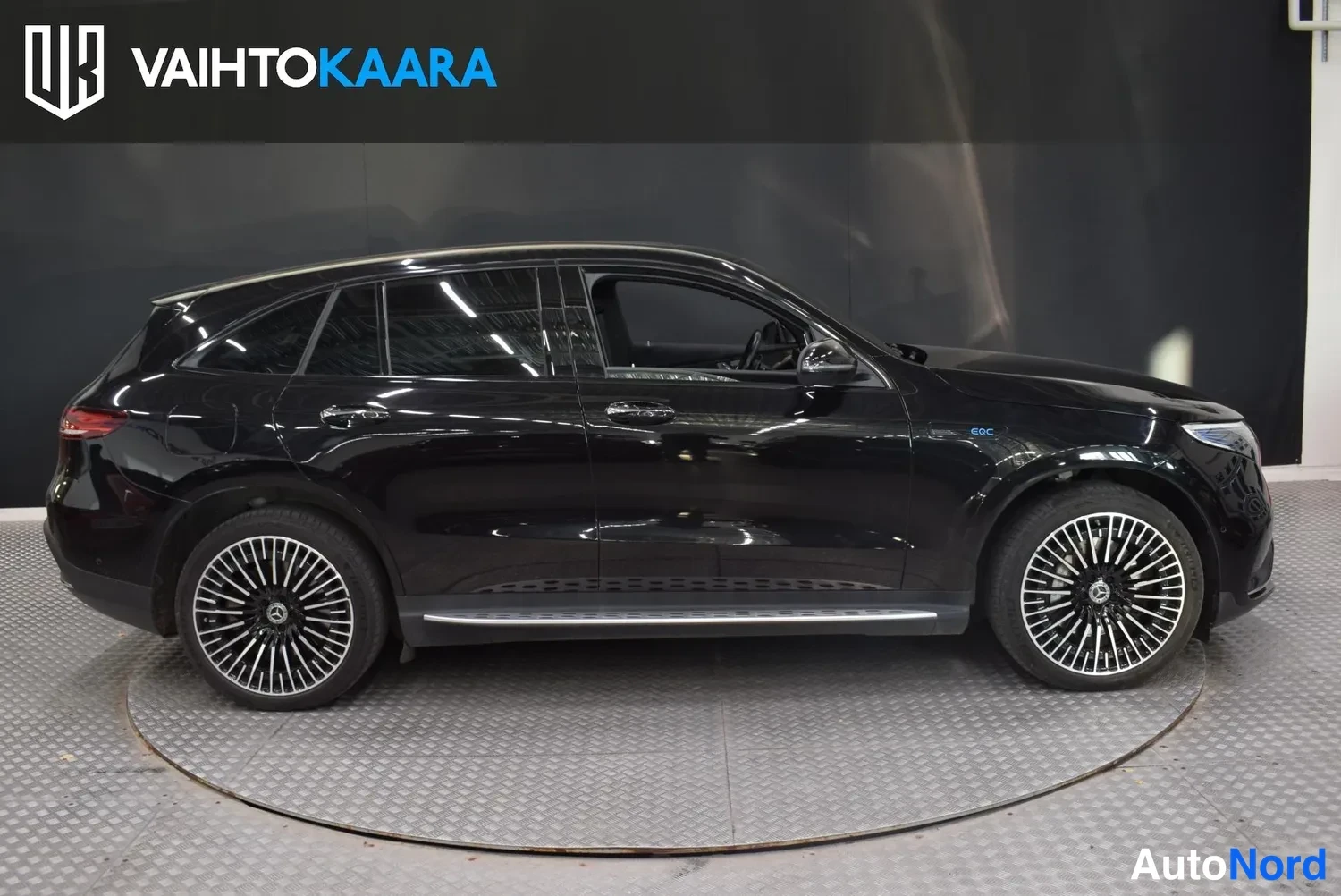 Sivulta: Mustan Mercedes-Benz EQC:n sivukuva vasemmalta puolelta, metallivanteet ja sivulista näkyvät.