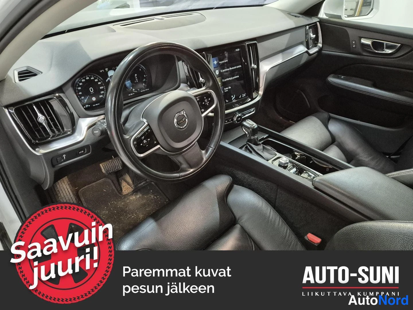 Muu: Volvo-auton kuljettajan paikka: ohjauspyörä, digitaalinen mittaristo ja keskikonsolin näyttö.