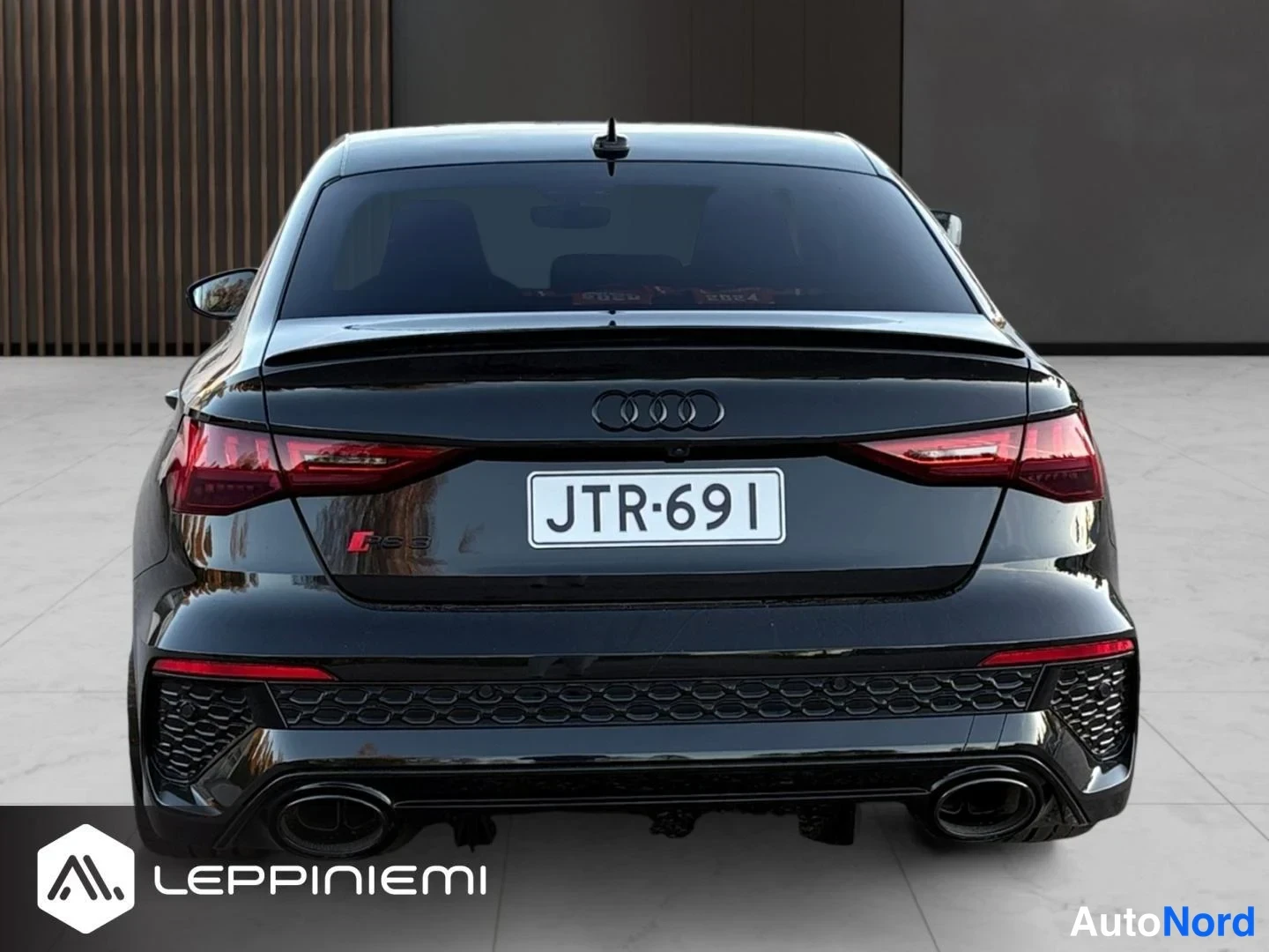 Takaa: Mustan sedanin suora takakuva, Audi-merkki, Rekisterikilpi, kahdet pakoputket