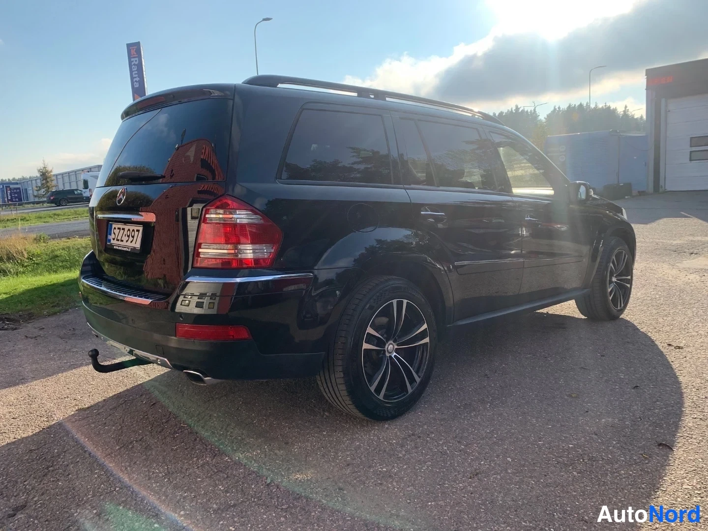 Takaviisto: Mustan Mercedes-Benz -maasturin takaosa ja kylki auringonpaisteessa, rekisterikilpi.