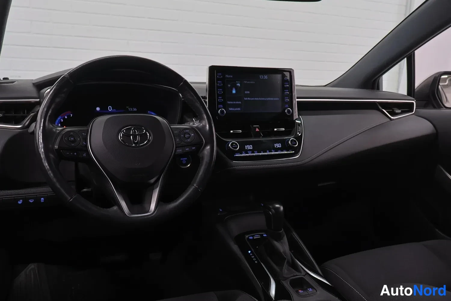 Yksityiskohta: Ohjaamon yleiskuva vasemmalta: Toyota-ratti, mittaristo, keskinäinen infotainment-näyttö ja automaattivaihteiston valitsin.