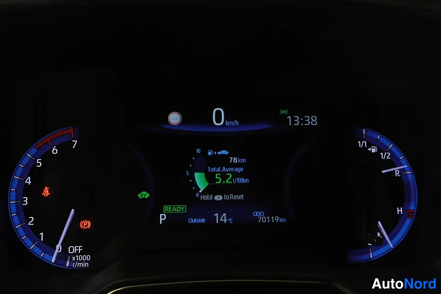 Yksityiskohta: Auton mittaristö näyttää nollaa km/h, READY-tilan, matkamittarin 70119 km, keskikulutuksen 5,2 l/100km ja kellonajan 13:38.