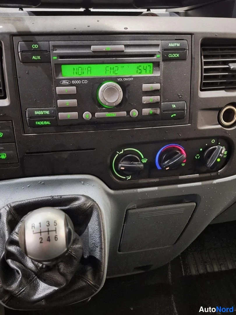 Muu: Auton sisätilan kuva: kojelaudassa Ford 6000 CD -radiolaite, ilmastointisäätimet ja manuaalivaihteen keila R-1-2-3-4-5-6 -merkinnöillä.