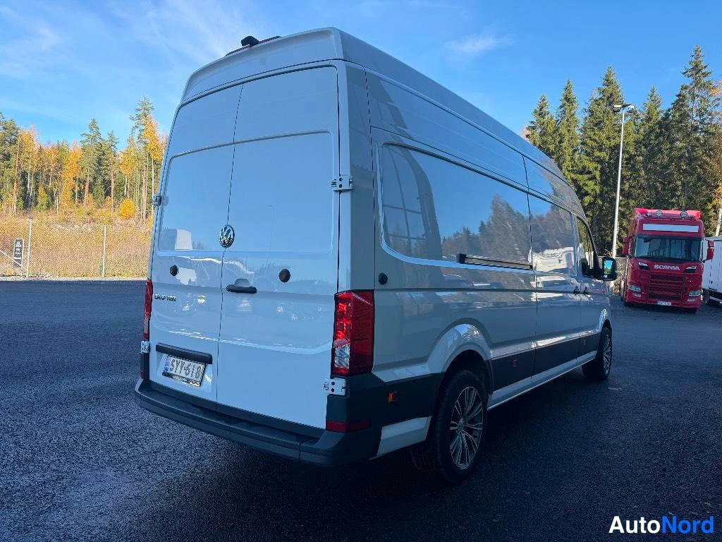 Takaviisto: Valkoisen Volkswagen Crafter -pakettiauton taka- ja sivunäkymä, takaovet ja rekisteritunnus näkyvät.