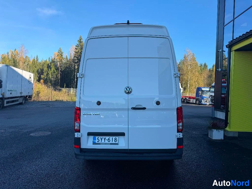 Takaa: Valkoisen pakettiauton takaosa suoraan takaa: kaksoisovi, Volkswagen-merkki, Crafter-teksti, takavalot ja rekisterikilpi.