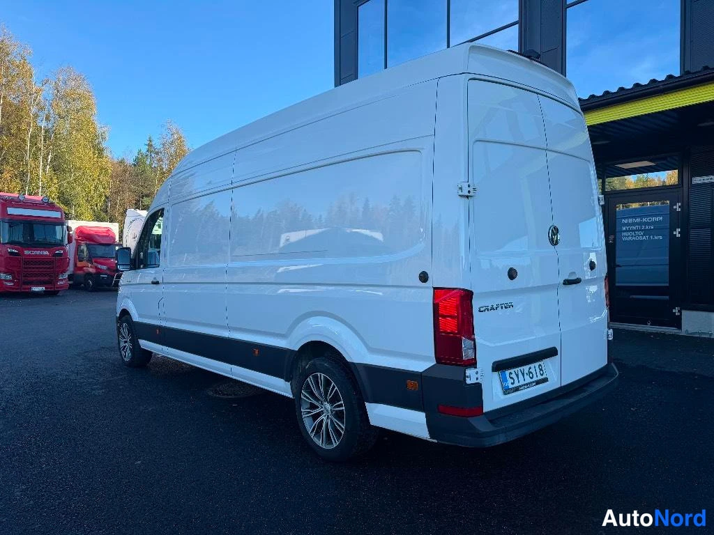 Takaviisto: Valkoinen Crafter-pakettiauto kolmella neljäsosaa takaa vasemmalta: pitkä korkea sido, takavalot, Crafter-teksti ja rekisterikilpi näkyvät.