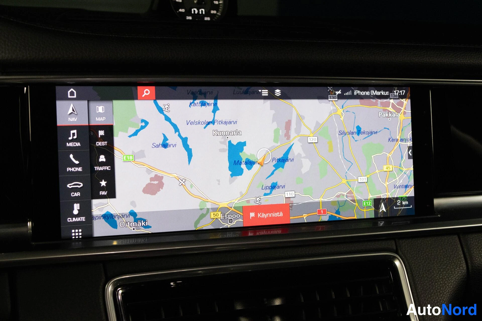 Yksityiskohta: Porsche Panameran kojelaudan infotainment-näyttö, jossa näkyy navigointikartta Espoon alueesta ja valikko NAV, MAP, MEDIA, DEST, PHONE, TRAFFIC, CAR, FAV ja CLI