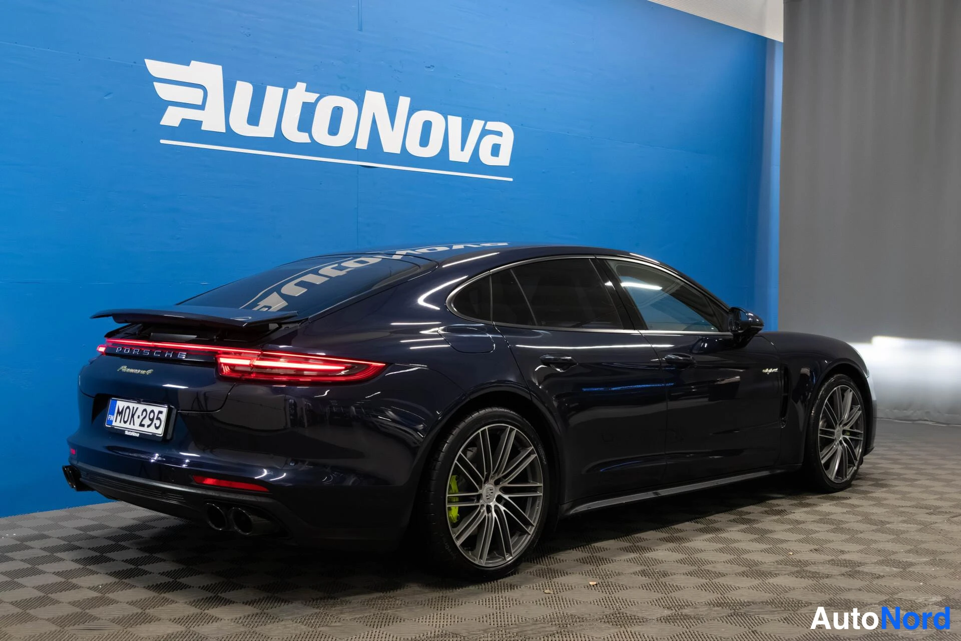 Takaviisto: Tummansininen Porsche Panamera takakulmasta vasemmalta, rekisteritunnus, PORSCHE-teksti takavalossa.
